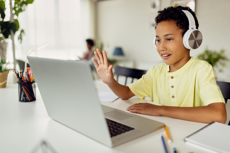african-american-boy-using-laptop-waving-during-video-call-while-homeschooling.jpg